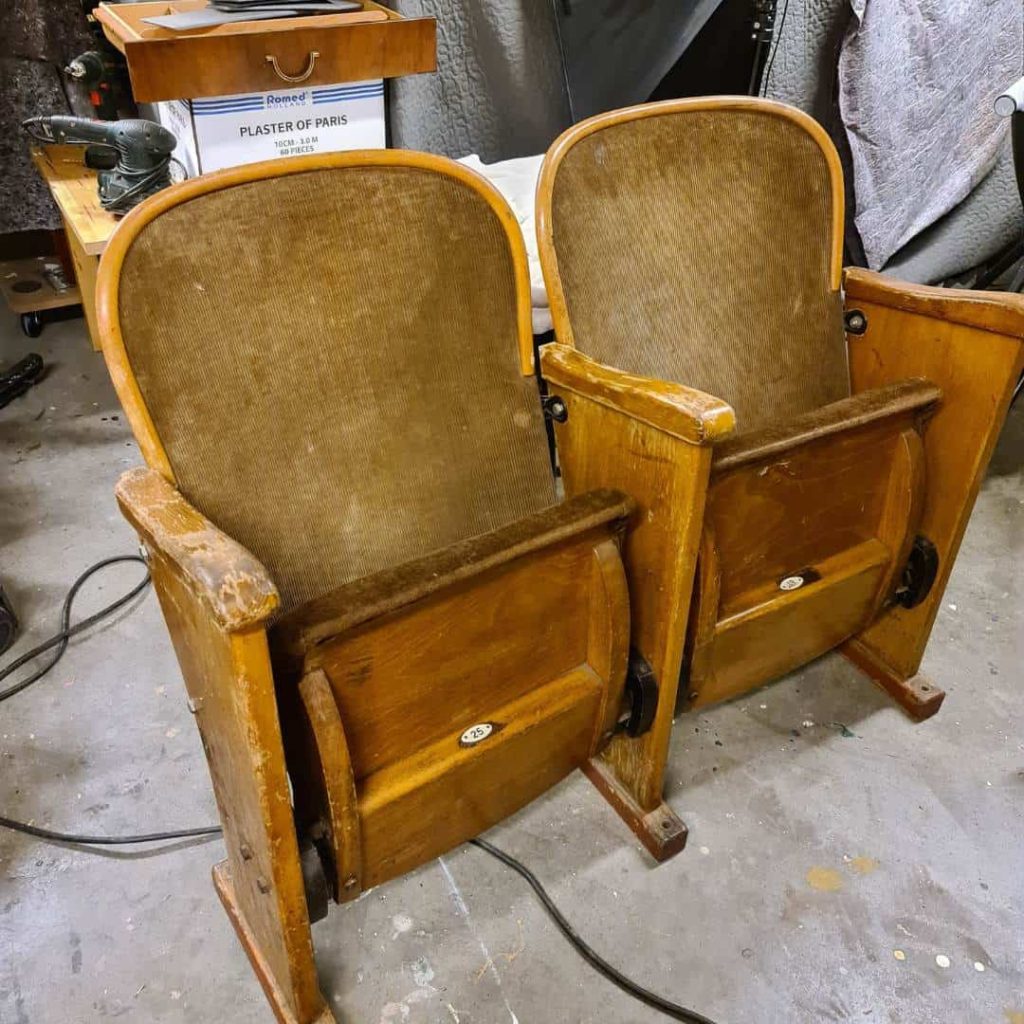 Vintage theatre chairs before refinishing with worn upholstery and scratched wood finish