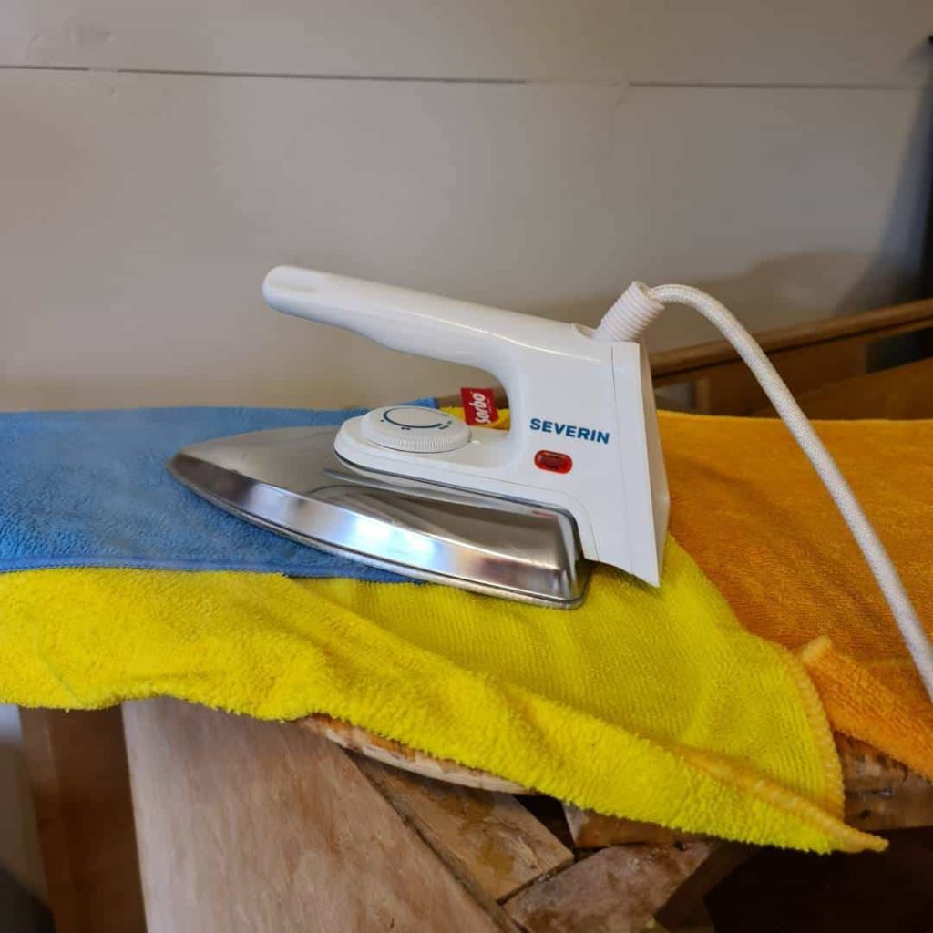 Iron on wet towels will loosen veneer for removal