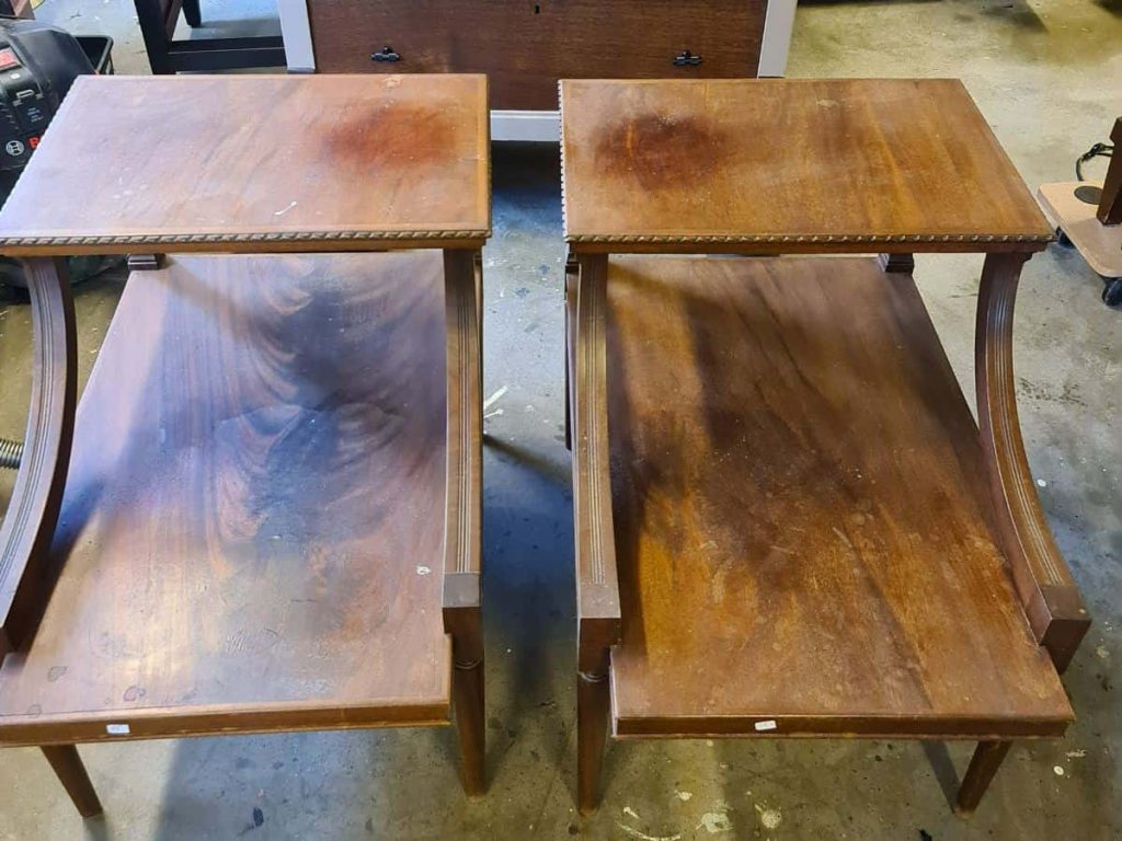 Two wooden tables placed side by side, both untreated but showing different levels of dark stains and discoloration. The image highlights the initial condition of the wood before the application of oxalic acid.